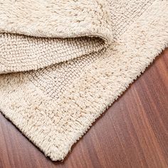 a close up of a rug on a wooden floor with a wood grained surface