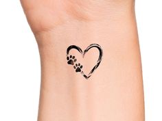 a heart shaped tattoo with paw prints on it