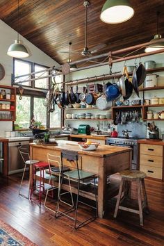 a kitchen with wooden floors and lots of hanging pots