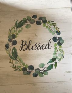 a painted wreath with the words, blessed on it and green leaves in black ink