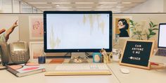 two computer monitors sitting on top of a desk next to each other in an office