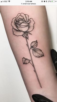 a black and white rose tattoo on the arm