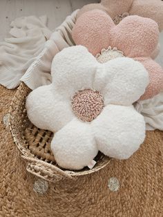 a basket filled with white and pink flowers on top of a woven mat next to other items