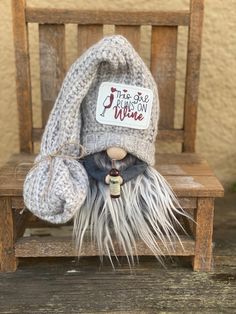 a small stuffed animal sitting on top of a wooden chair wearing a knitted hat