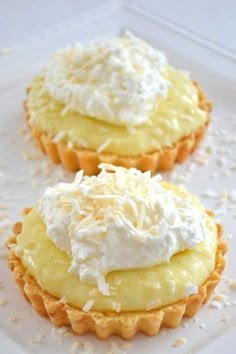 two cupcakes with whipped cream and coconut on top