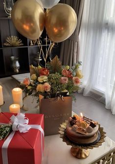 a table topped with a cake and balloons