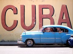 an old blue car is parked in front of a sign that says curaca