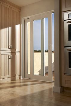 an empty kitchen with sliding glass doors leading to the patio and deck area that overlooks the ocean