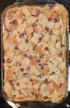 a casserole dish with cranberries and bread in it