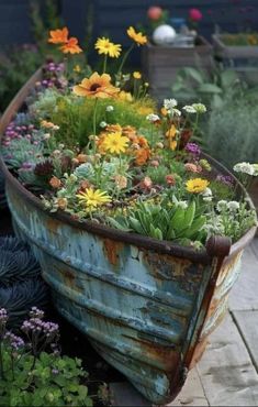 an old boat is filled with flowers and plants