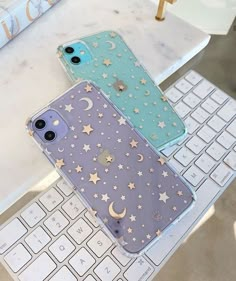 three iphone cases sitting on top of a computer keyboard and phone case next to each other