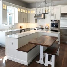 a kitchen with white cabinets and wooden counter tops