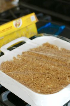 a white casserole dish sitting on top of a stove with crumbs in it