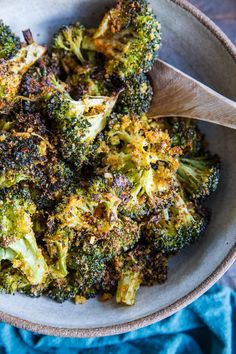 a white bowl filled with broccoli on top of a blue cloth covered table