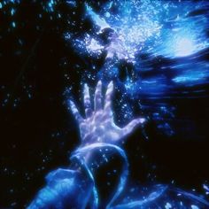 a hand reaching for something in the air with blue light coming from it's hands