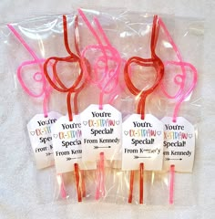 four pink toothbrushes with tags on them sitting in plastic bags next to each other