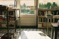 a room filled with lots of books next to a window