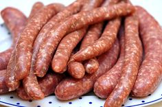 several sausages are stacked on a white and blue plate