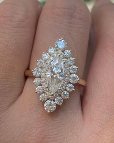 a woman's hand with a diamond ring on top of her finger and an engagement band