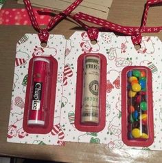 three christmas gift tags with candy in them and a roll of money on the top