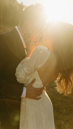 a bride and groom kissing in the sun