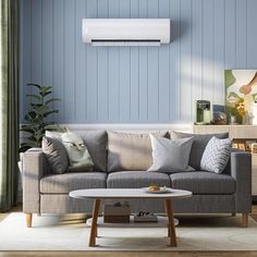 a living room with a couch, coffee table and air conditioner on the wall