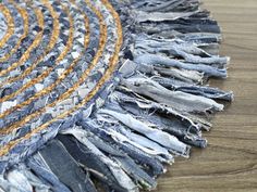 an area rug made out of old jeans on a wooden floor with fraying around the edges