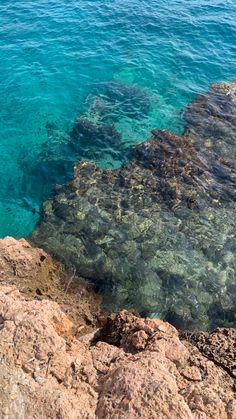 the water is crystal blue and clear with some rocks on it's side,