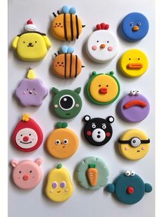 many different kinds of cookies are arranged on a white surface, including one with eyes and nose