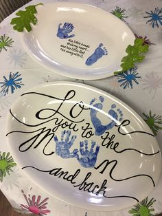 two plates with handprints on them and the words love you to the moon and back