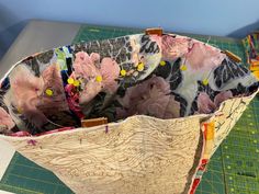 a close up of a cloth bag on a table with scissors and cutting board in the background