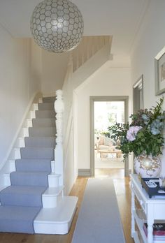 an image of a hallway with stairs and flowers