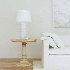 a white couch sitting next to a table on top of a hard wood floor