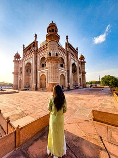 a woman standing in front of a large building