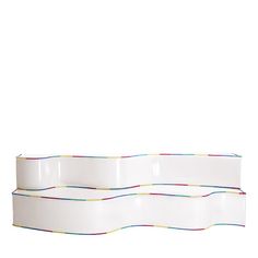 three white dishes stacked on top of each other with colorful lines running across the edges