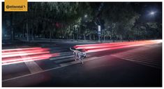 a dog walking across a street at night with red light streaks coming from its mouth