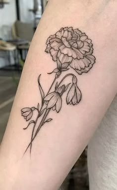 a black and white flower tattoo on the arm