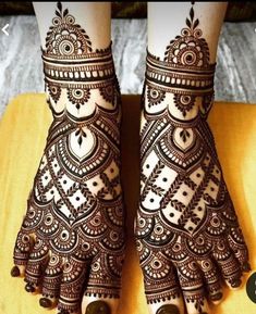 the feet and hands of a woman with henna tattoos