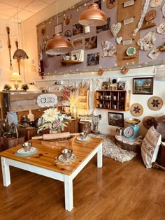 a living room filled with furniture and lots of plates on the wall next to a coffee table