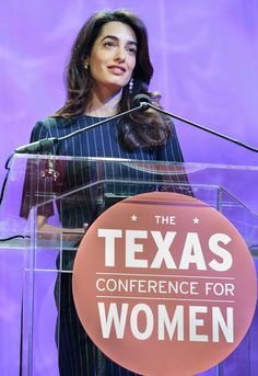 a woman standing at a podium with the texas conference for women logo on her chest