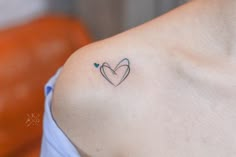 a woman with a heart tattoo on her left shoulder and the word love written in blue ink