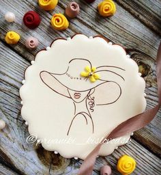 a cake decorated with an image of a woman wearing a hat and holding a yellow flower