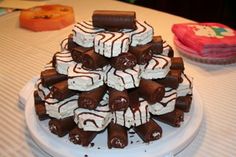 a white plate topped with lots of cake covered in chocolate and marshmallows