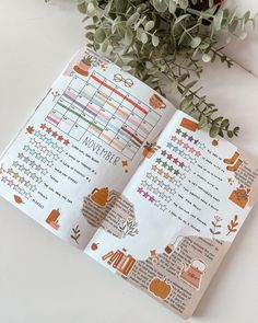 an open planner with stickers on it next to a plant and potted plant