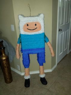 a knitted cartoon character standing in front of a door