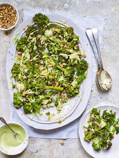 broccoli and other vegetables are on a plate with spoons next to it