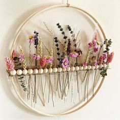 an embroidery hoop with flowers hanging on it