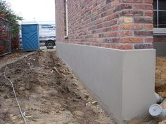 the corner of a brick building that is being constructed into a foundation for a fire hydrant