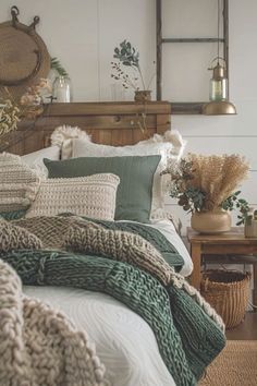 a bed with pillows and blankets on top of it next to a wooden table in front of a mirror