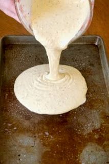 a person pouring batter into a pan on top of a table